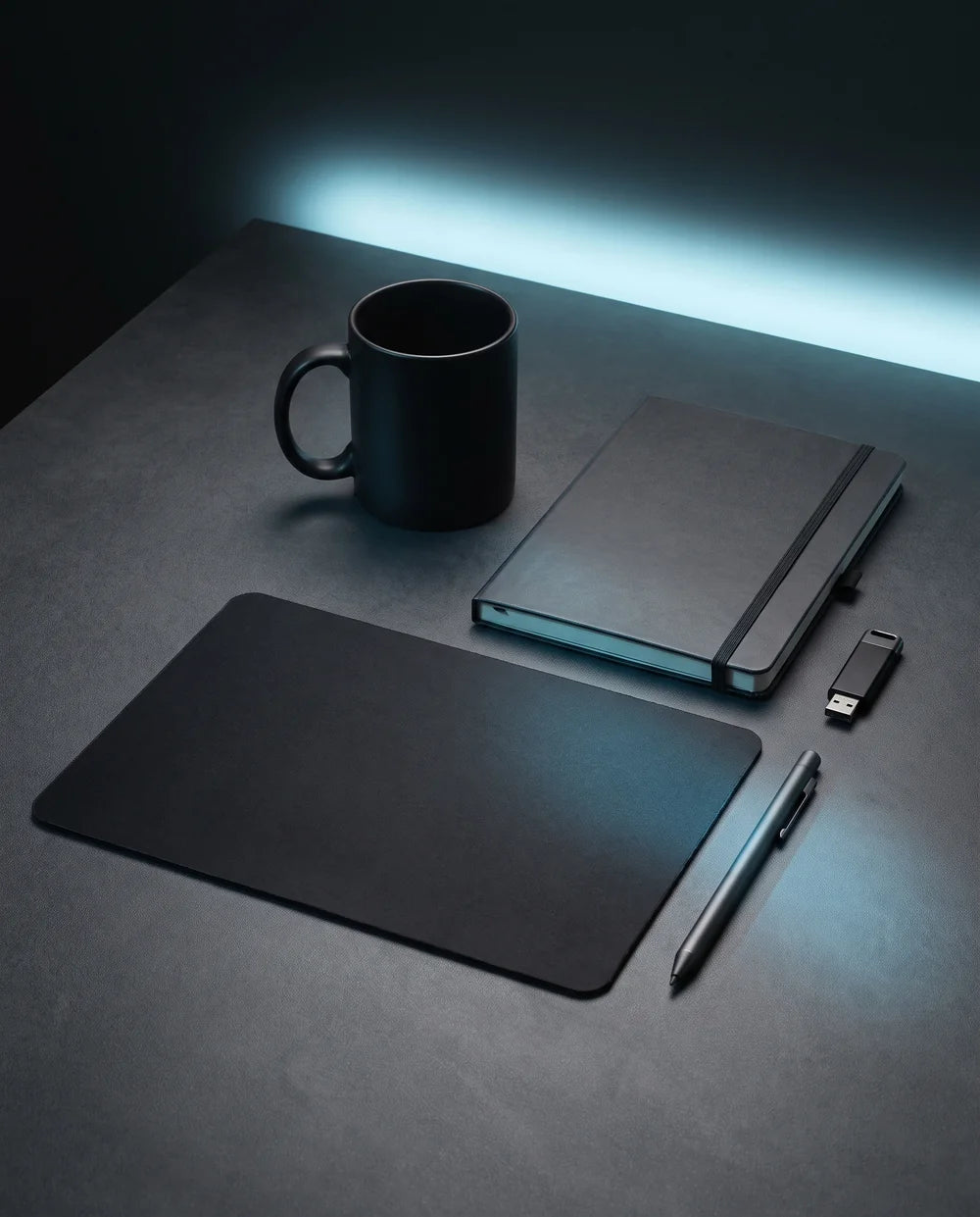 Black mug, notebook and mousepad with cyan glow